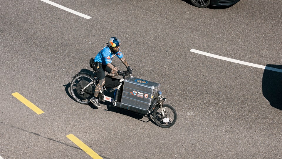 Ein Velokurier mit Cargo-Bike