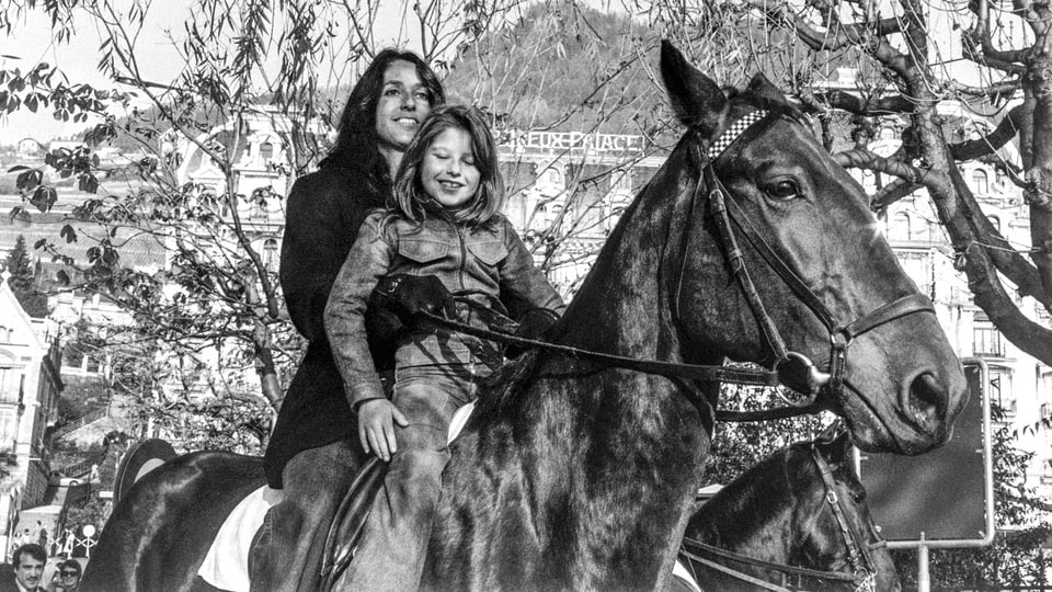 Joan Baez auf einem Ross, vor ihr ein Mädchen, in Montreux