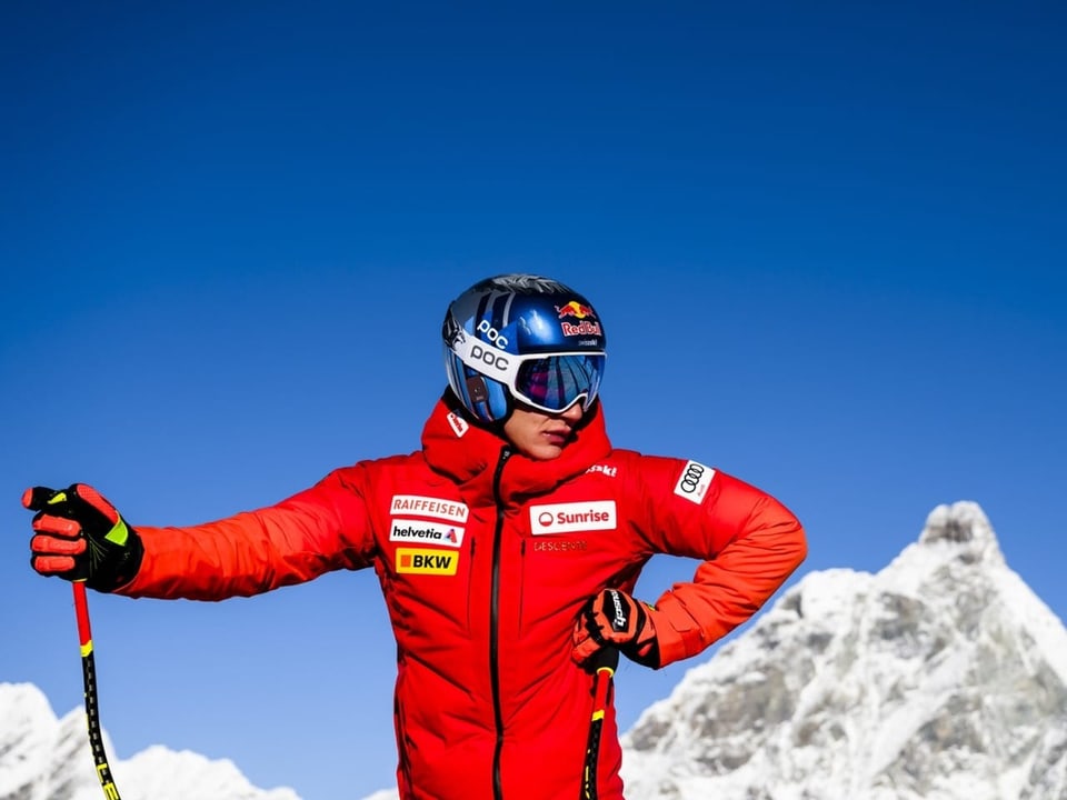 Marco Odermatt stützt sich auf die Skistöcke. Hinter ihm, der blaue Himmel und das Matterhorn.
