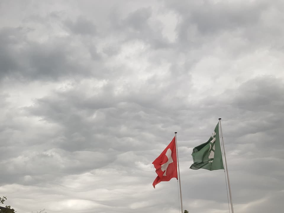 Wellige Wolken und zwei Fahnen.