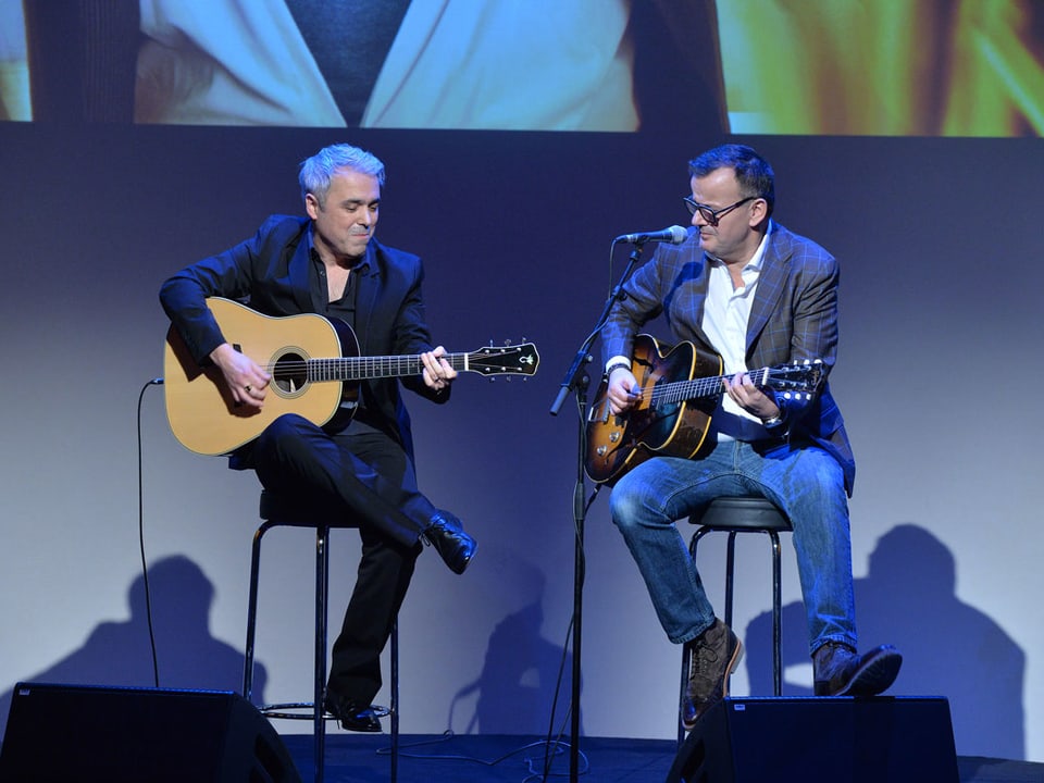 Zwei Musiker mit Gitarren auf der Bühne.