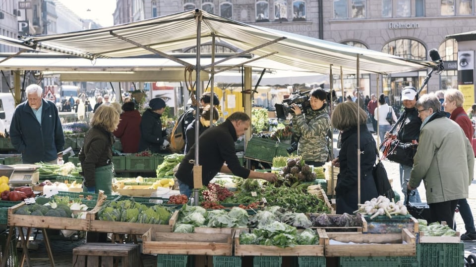 Leute an einem Marktstand in Basel. 