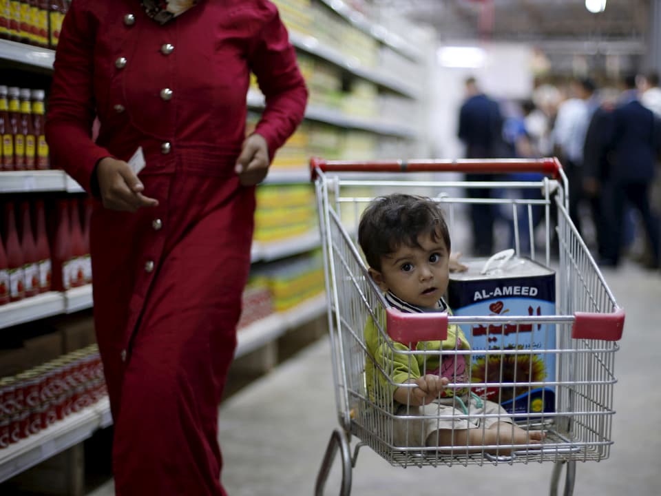 Blick auf einen Einkaufswagen mit einem Kleinkind in einem Lebensmittelgeschäft in Zaatari.