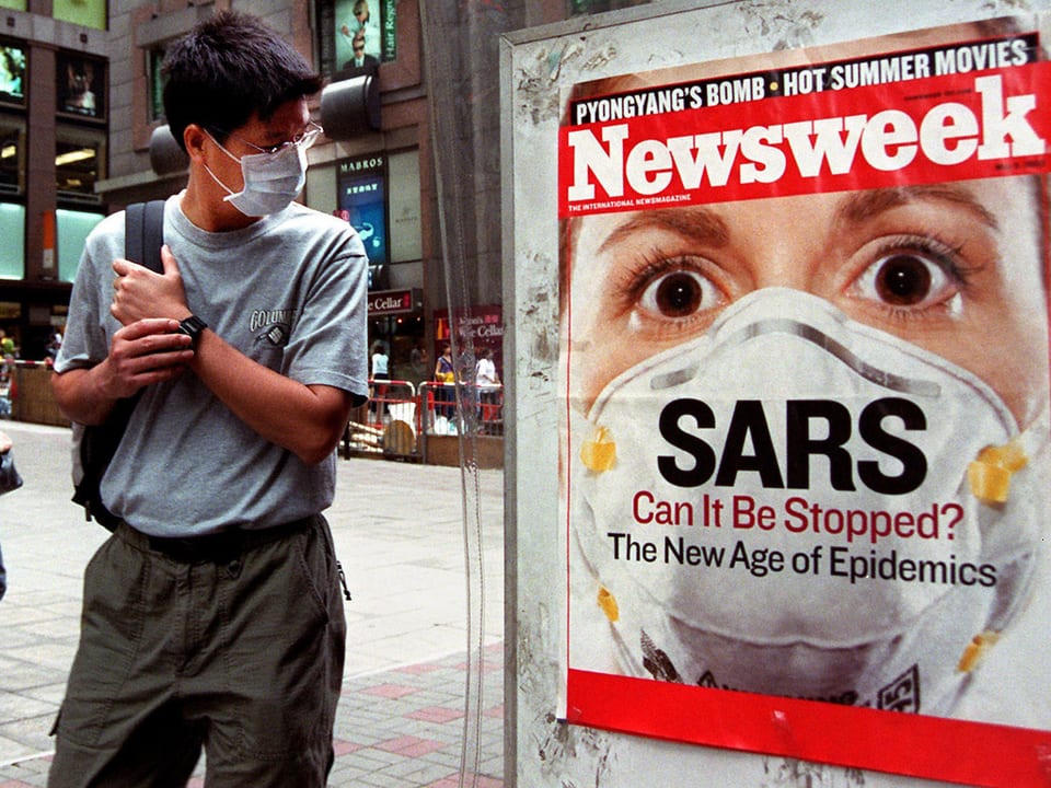 Ein Mann mit Gesichtsmaske betrachtet in Hong Kong das Sars-Titelblatt des US-Magazins «Newsweek»