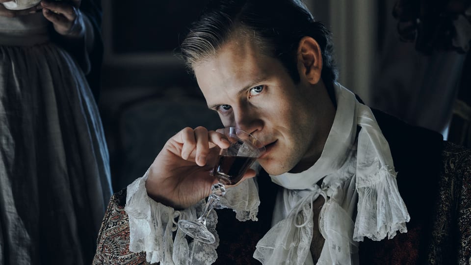 Mann in historischer Kleidung trinkt aus einem Glas