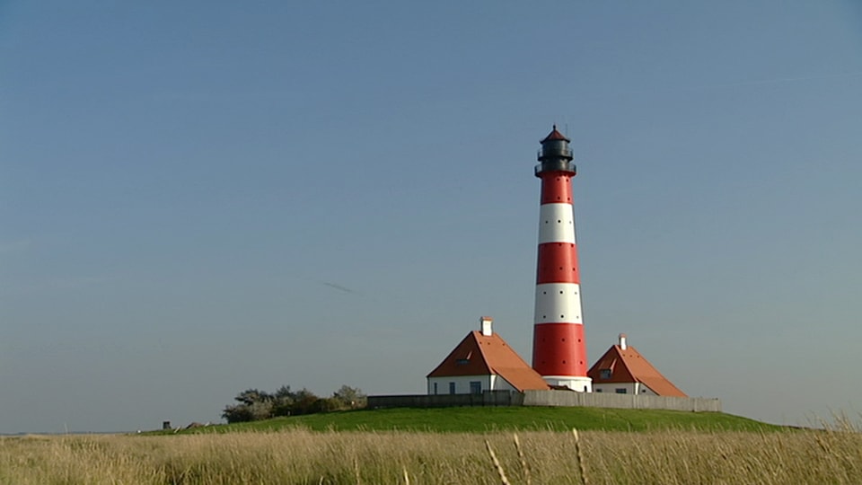 Ein typischer Nordfriesischer Leuchtturm vor blauem Himmel.
