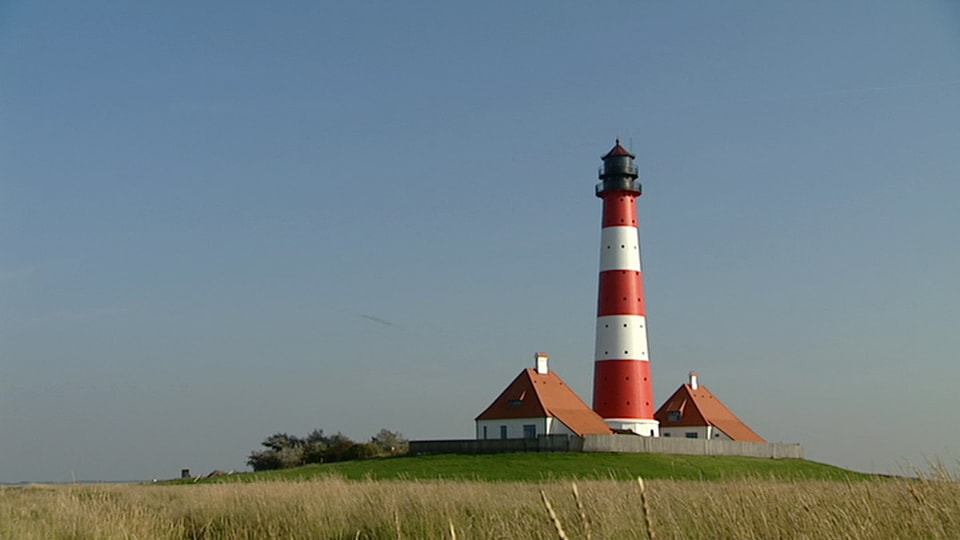 Die Nordfriesen: Ein typischer Nordfriesischer Leuchtturm vor blauem Himmel.