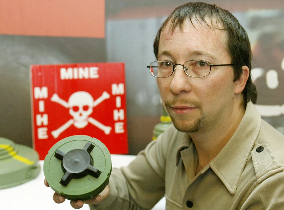 DJ Bobo hält eine Mine in der Hand. Er engagiert sich für Landminenopfer.