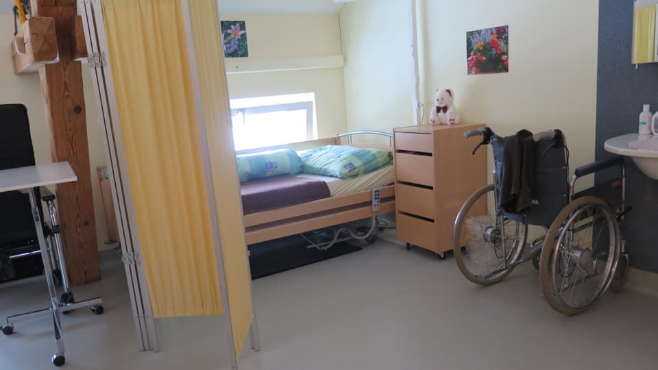 Zimmer in einem Altersheim: mit Pflegebett und Rollstuhl