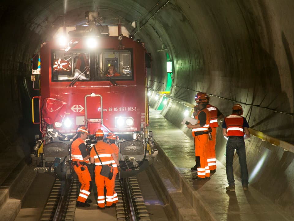 Lokomotive und Arbeiter in einer Tunnelröhre
