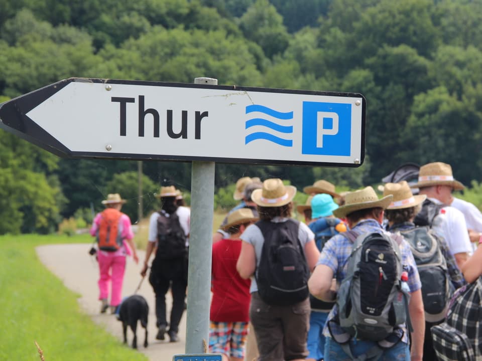 Ein Wegweiser zeigt Richtung Thur und enthält ebenfalls ein Parkplatz-Symbol.