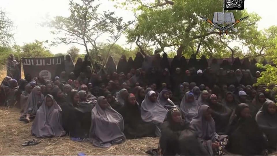 Von Boko Haram verschleppte Schulmädchen, schwarz verschleiert in einem Hof. 