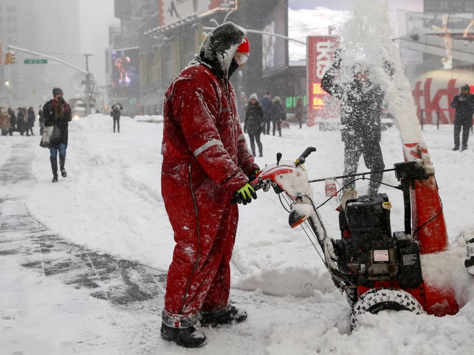 Ein Mann schafft mit einer Maschine den Schnee vom Times Square weg