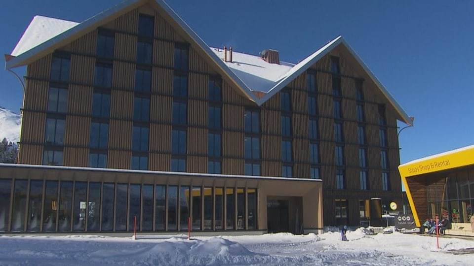 Hotel mit Holzfassade im Schnee.