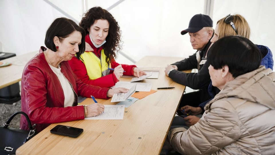Christine Schraner Burgener füllt mit Flüchtlingen die Registrierungsformulare beim Bundesasylzentrum Zürich aus.