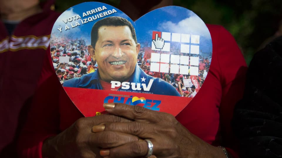 Eine Frau hält ein Bild von Venezuelas Präsidenten Hugo Chávez in der Hand.