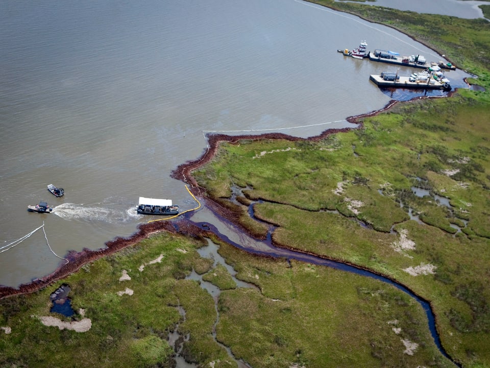 Von Oben: Küstenstreifen mit Ölrand und eine Austernfarm.