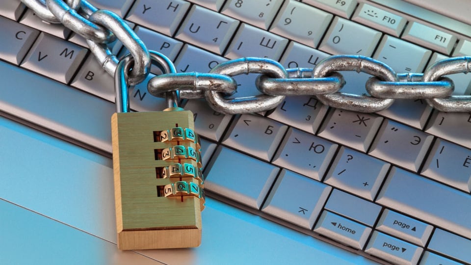 Computertastatur mit einer Sicherheitskette und einem Sicherheitsschloss.
