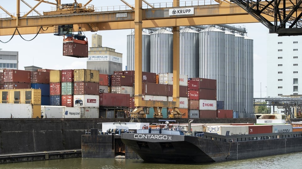 Container werden am Contargo Container-Terminal am Port of Switzerland in Basel auf ein Frachtschiff umgeladen.