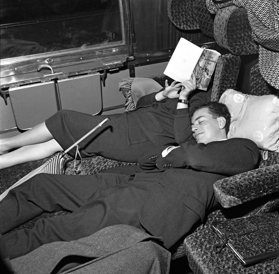 Reisende schlafen im Zug.