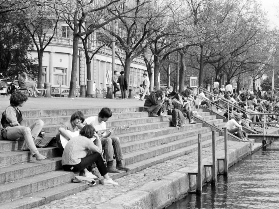 Schwarz-weiss Foto vom Limmatquai mit einigen Menschen aus dem 1980er-Jahren