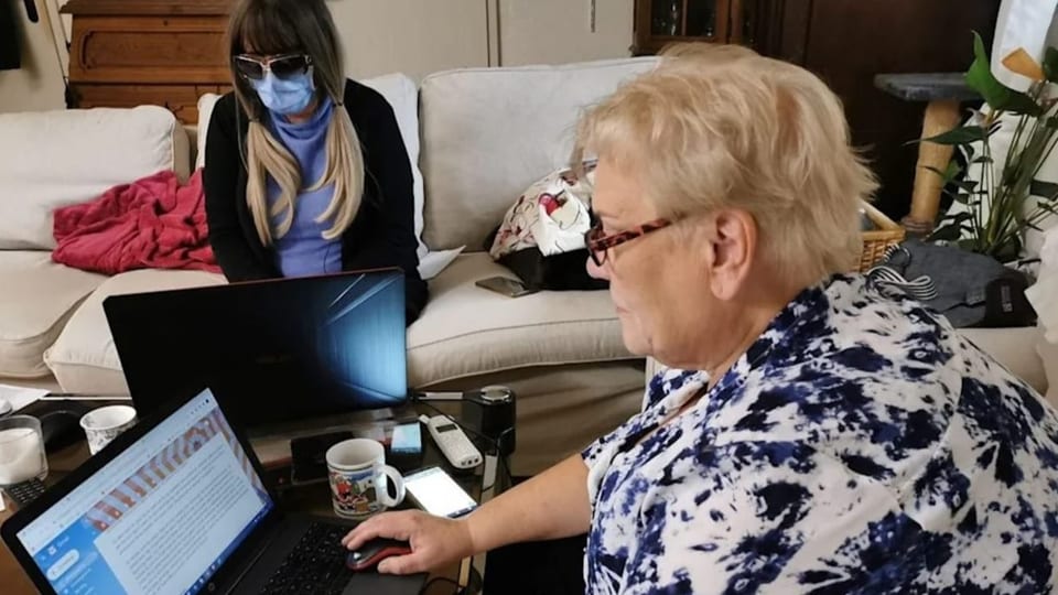 Eine Frauen sitzen an ihren Computers.