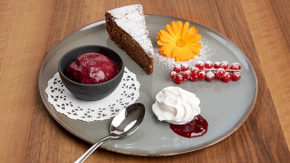 Sonjas Schoggikuchen mit Trübeli, Cassisglace und Holzofen-Meringue auf rotem Johannisbeerspiegel.