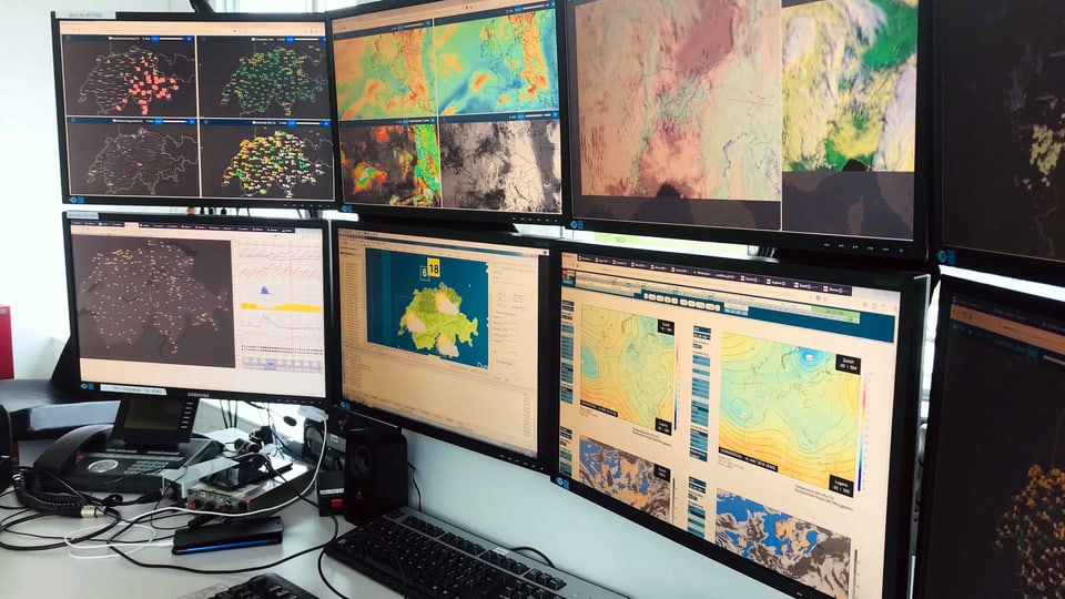 Auf acht Monitoren sind Satellitenbilder, Blitz- und Radarkarten und verschiedene Messwerte zu sehen.