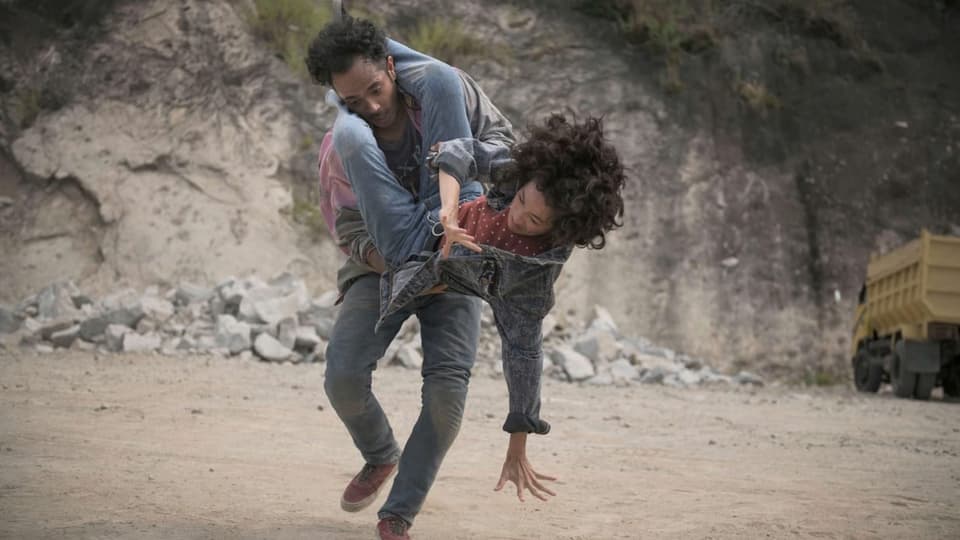 Filmszene: Ein Mann und eine Frau kämpfen in einem Steinbruch