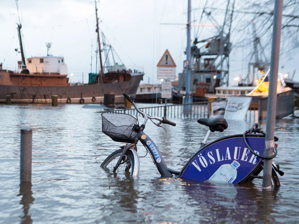 Überflutetes Hamburger Hafenviertel. Ein Fahrrad steht im Wasser. 