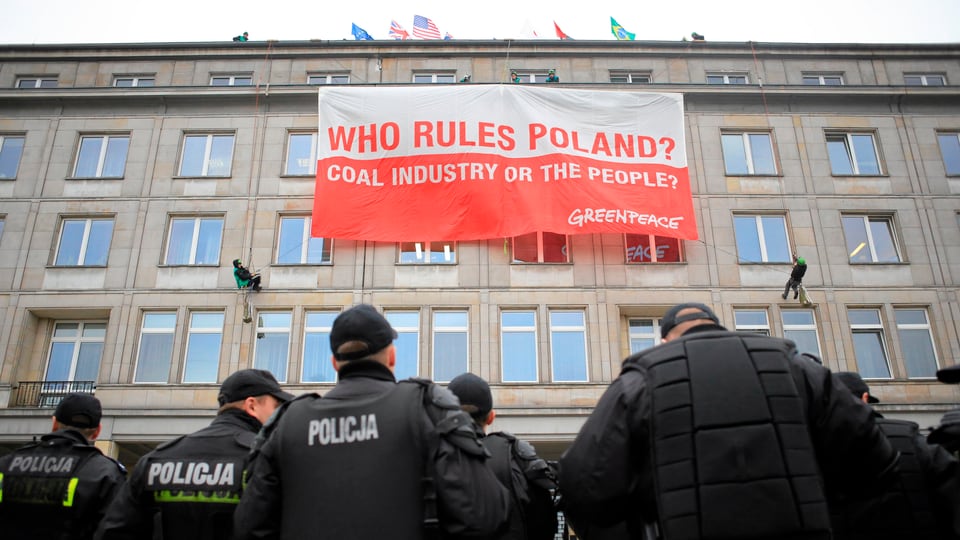 «Wer regiert Polen? Die Kohleindustrie oder das Volk?» steht auf deinem Banner an einer Hauswand, Polizisten davor.