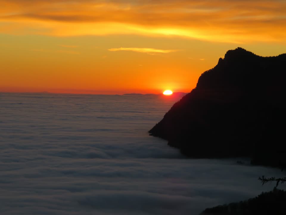 Nebelmeer bei Sonnenuntergang mit Felsen rechts
