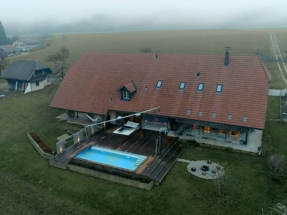 Ein grosses Bauernhaus mit einem Pool.