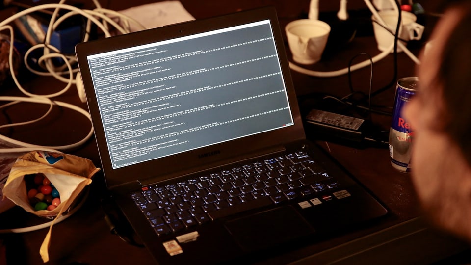 Auf einem Laptop laufen Code-Zeilen durch.