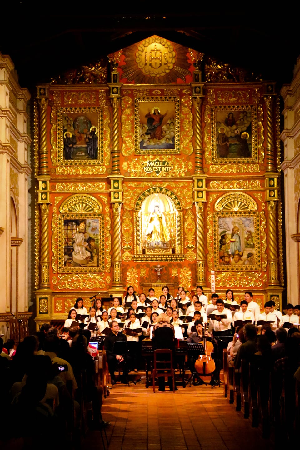 In einer üppig gestalteten und dekorierten Kirche singen Kinder in einem Chor.