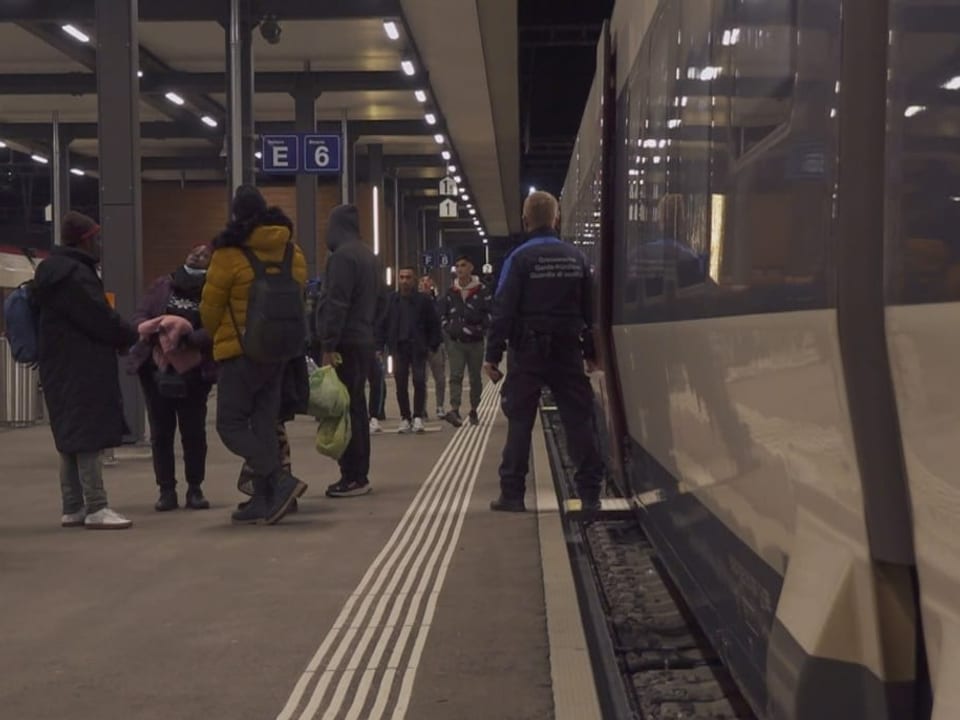 Ein Grenzwächter steht neben dem Eingang eines Zuges. 