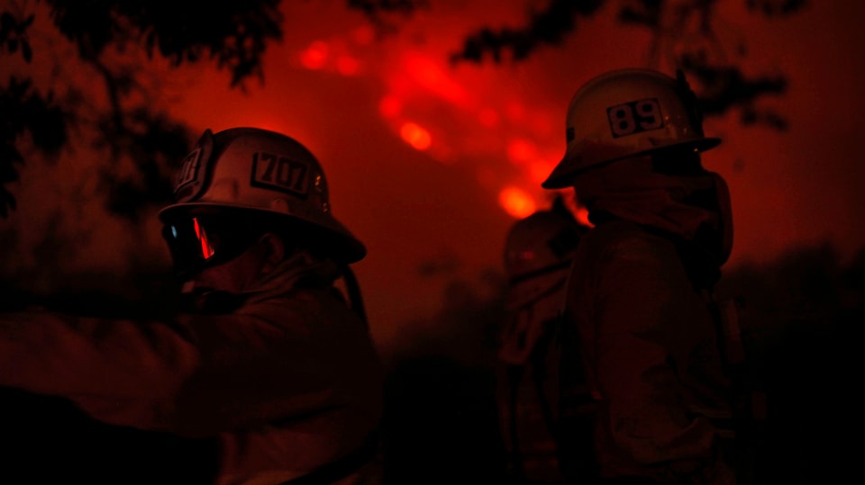 Zwei Feuerwehrmänner vor einem Buschbrand in Kalifornien