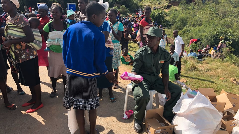 Ein Militärangehöroger verteilt Hilfsgüter