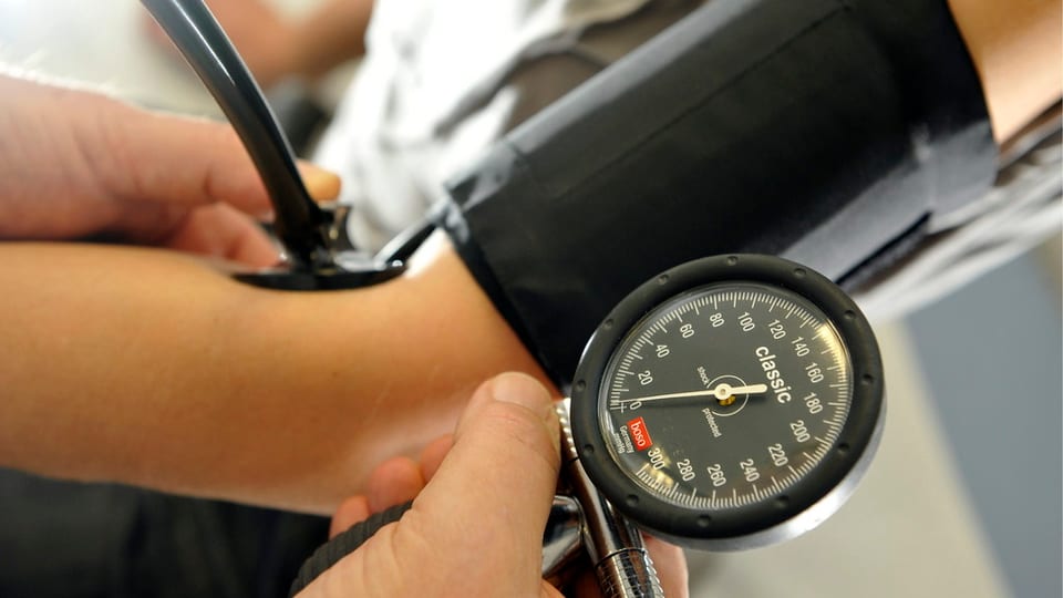 Ein Arzt misst den Blutdruck.