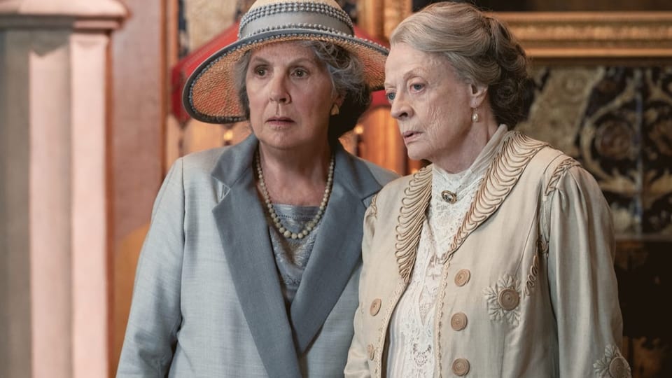 Filmszene: Zwei ältere, elegant gekleidete Frauen stehen nebeneinander.