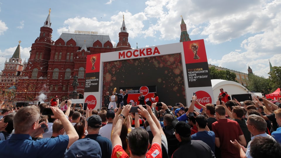 Menschenmenge vor einer Bühne, die vor dem Kreml aufgestellt ist.
