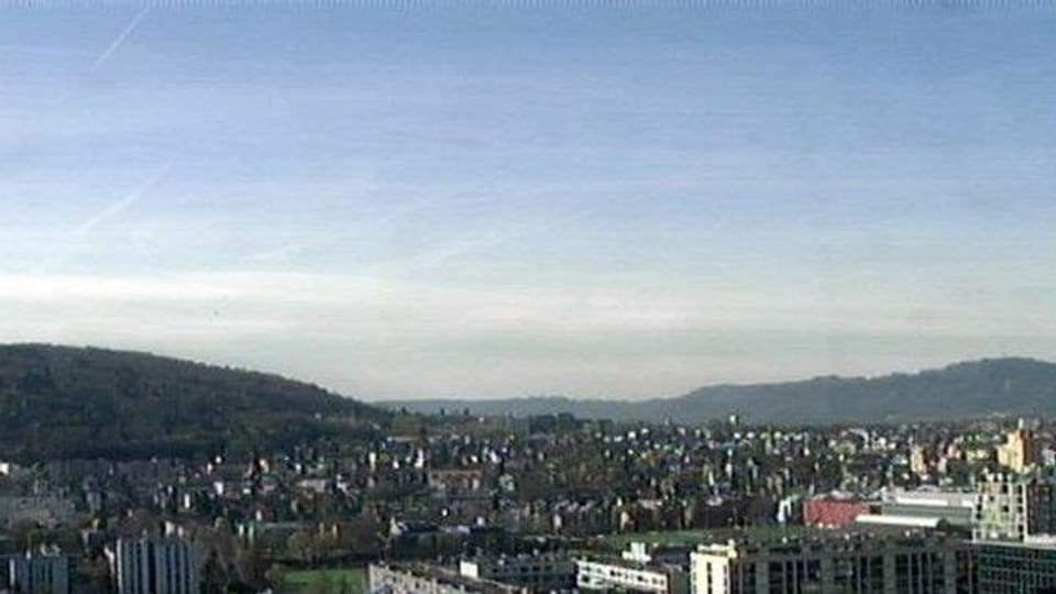 Ein Blick über die Stadt Zürich. Der Himmel ist im unteren Teil grau (die Leewelle), im oberen Teil des Bildes blau mit nur wenigen Schleierwolken.