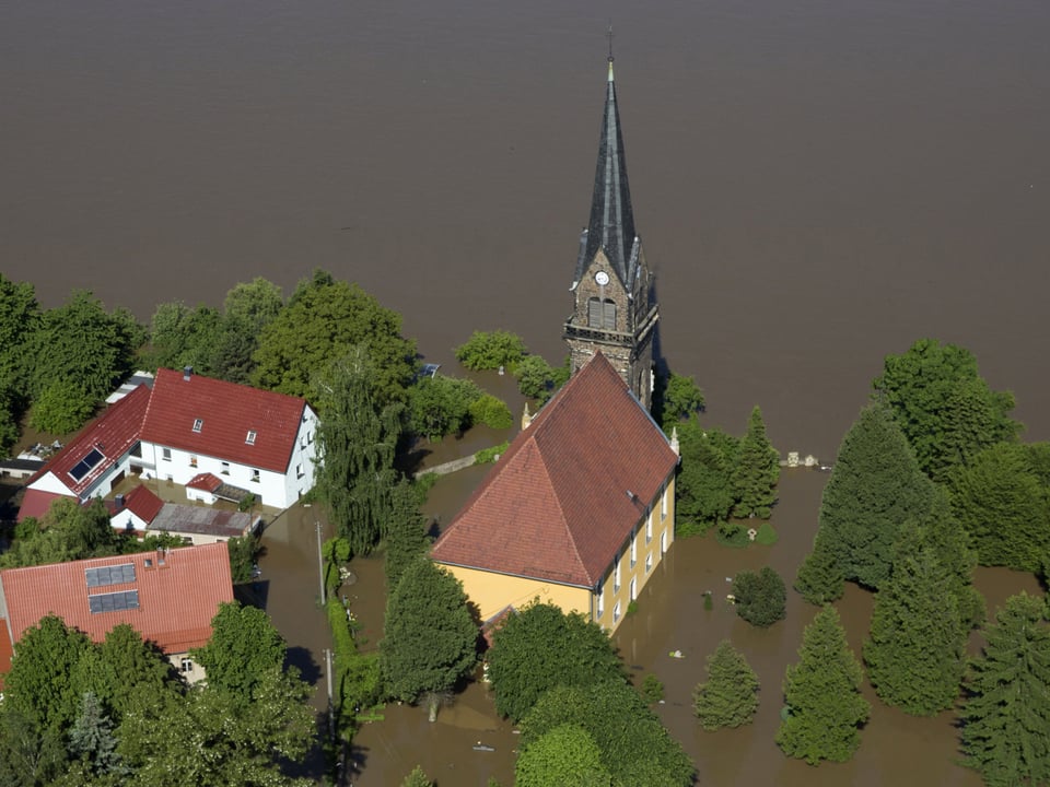 Gelbe Kirche komplett von Wasser eingschlossen. Luftaufnahme