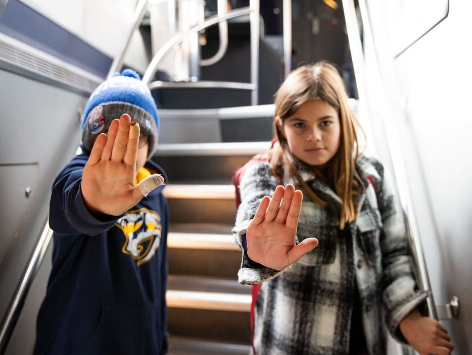 Lino und Jana im Zug mit einer klaren «Stopp»-Pose.