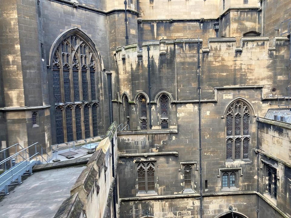 A close-up of the architectural details of a Gothic cathedral with windows and sculptures.