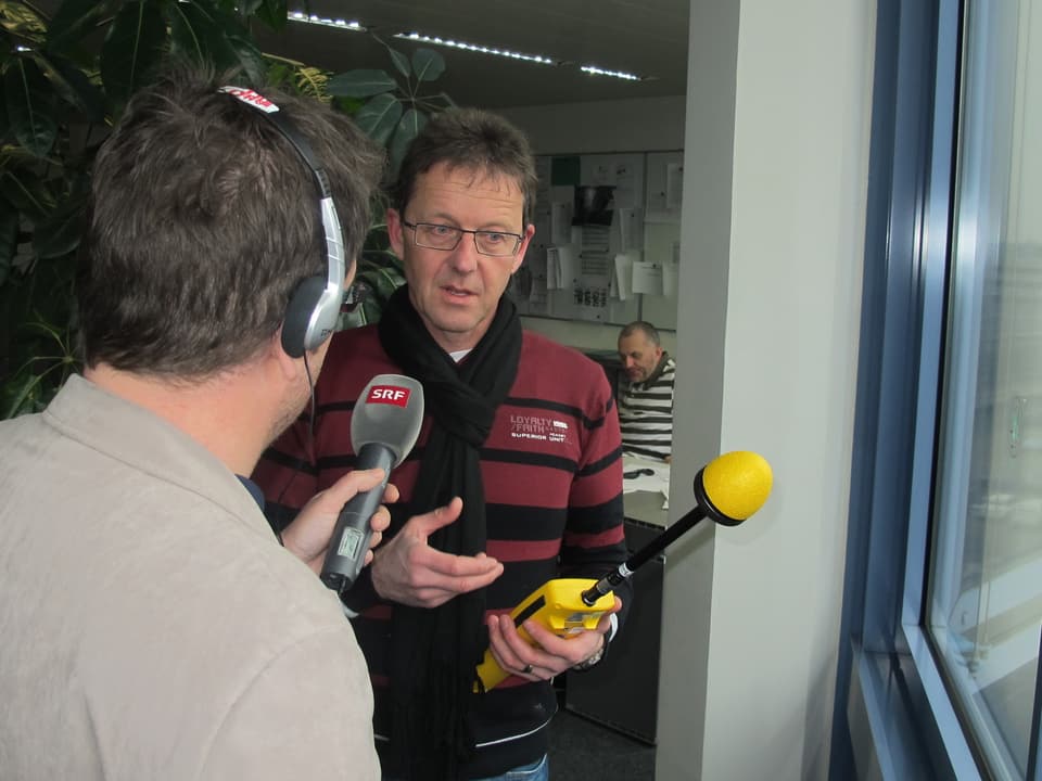 Markus Gugler steht mit dem Messgerät am Fenster.