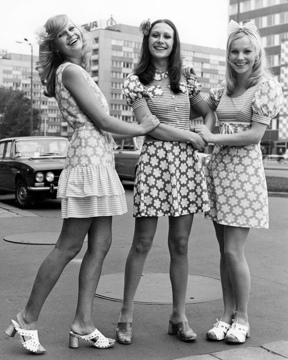 Schwarzweiss-Bild mit drei jungen Damen in blumigen Minikleidern