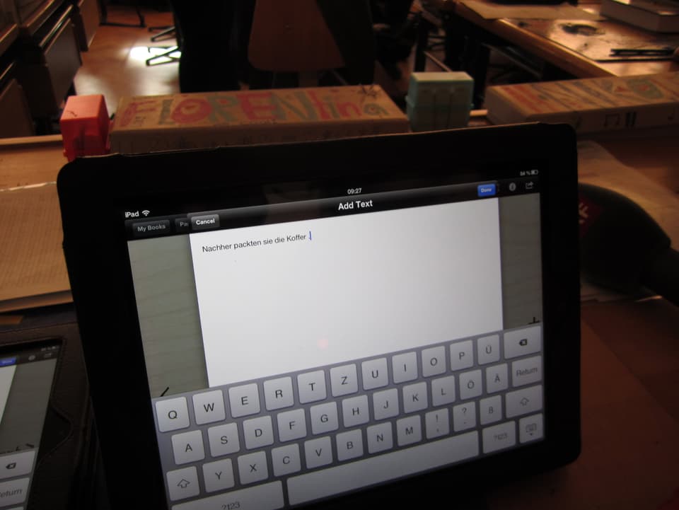 Ein schwarzes Ipad, auf dem Bildschirm die Tastatur und ein Text.