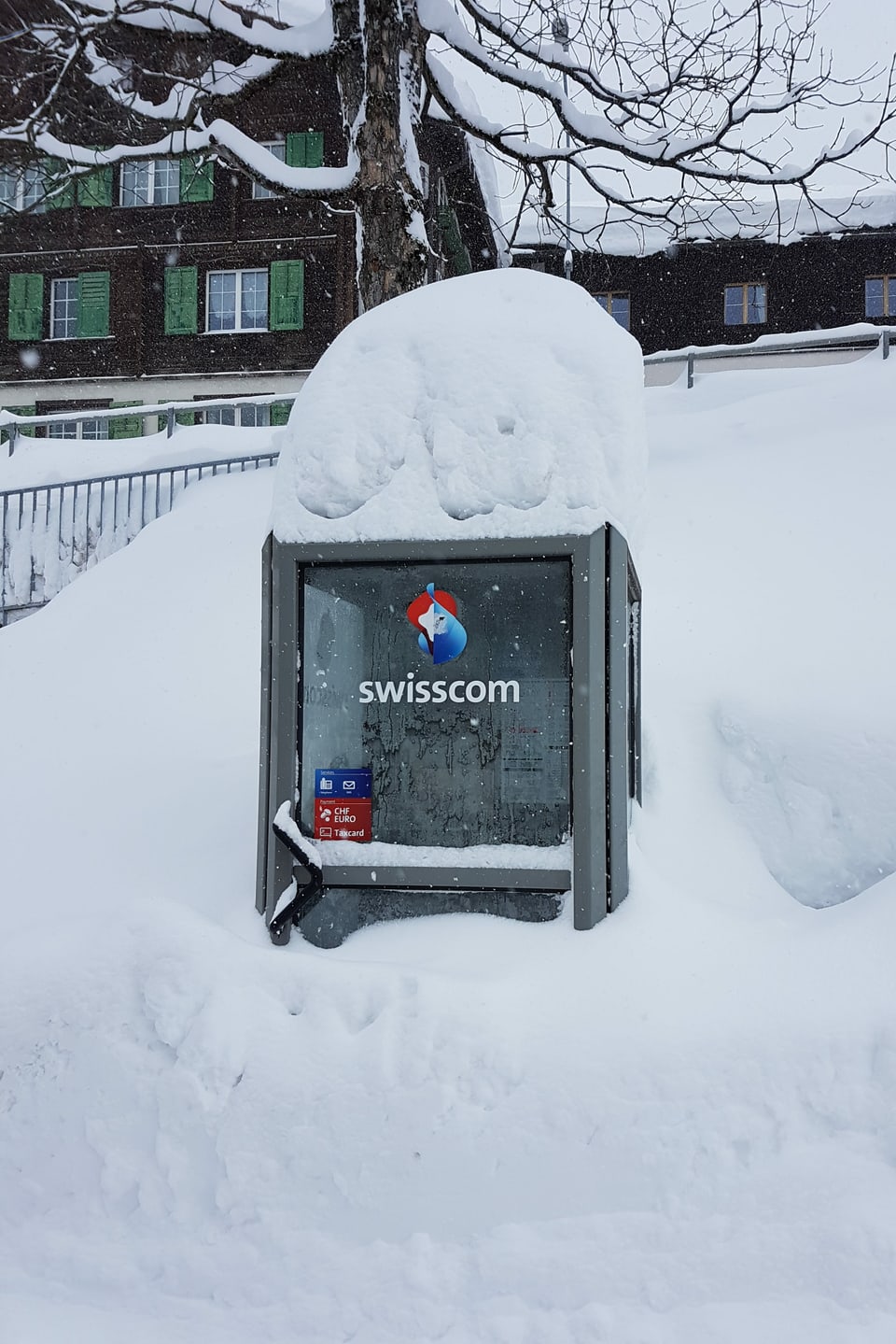 Eine alte Telefonkabine versinkt in Klosters im Schnee.