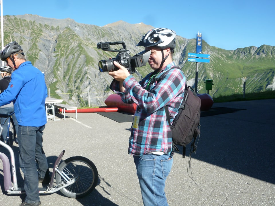 Ein Mann mit Helm filmt mit einer Kamera